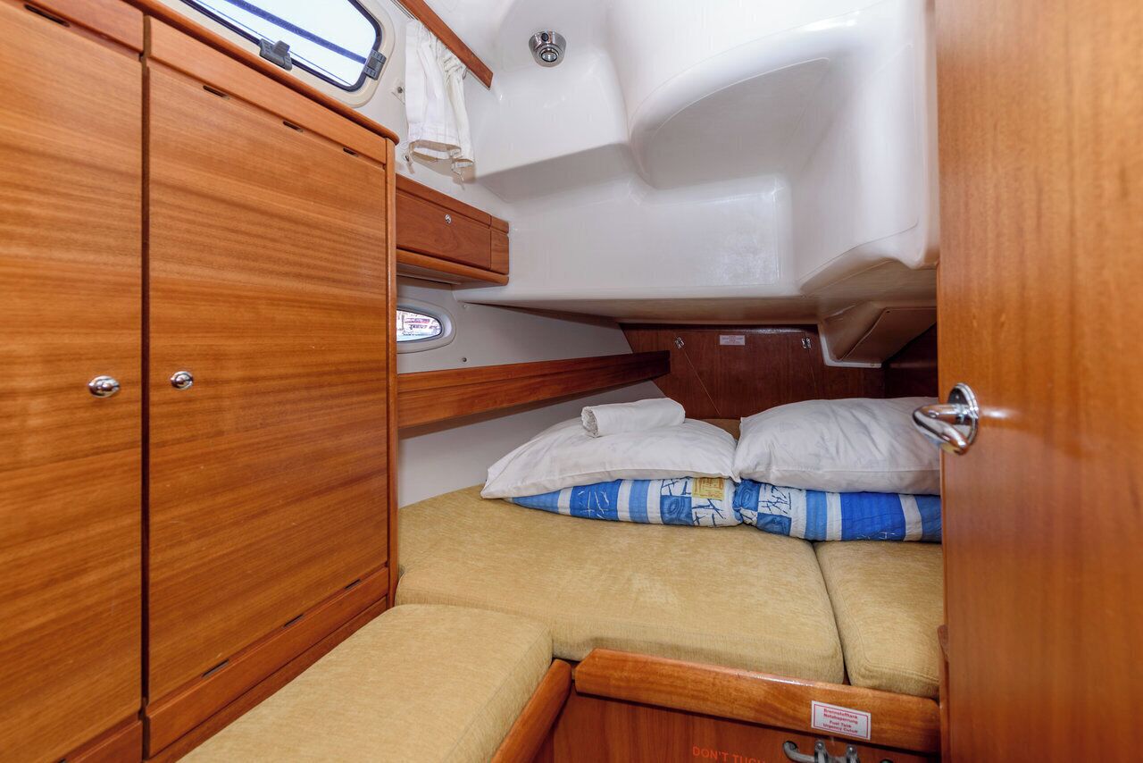 Ein kleines, kompaktes Abteil mit Bett, Staufächern und einem kleinen Fenster.