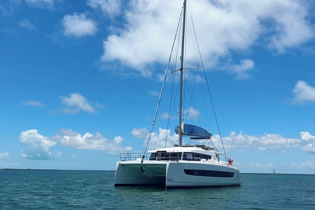 Een witte jacht met de naam 'BALI' op de zijkant, varend op het water.