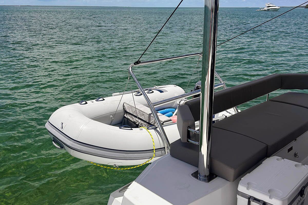 Un bateau équipé d’un canot pneumatique blanc, d’une banquette noire rembourrée et offrant une vue dégagée sur l’eau.