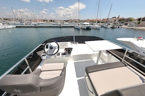 A boat's interior with a steering wheel, control panel, and seating area. - Sun-Kissed Sailing Adventure in Zadar, Croatia (Biograd na moru)