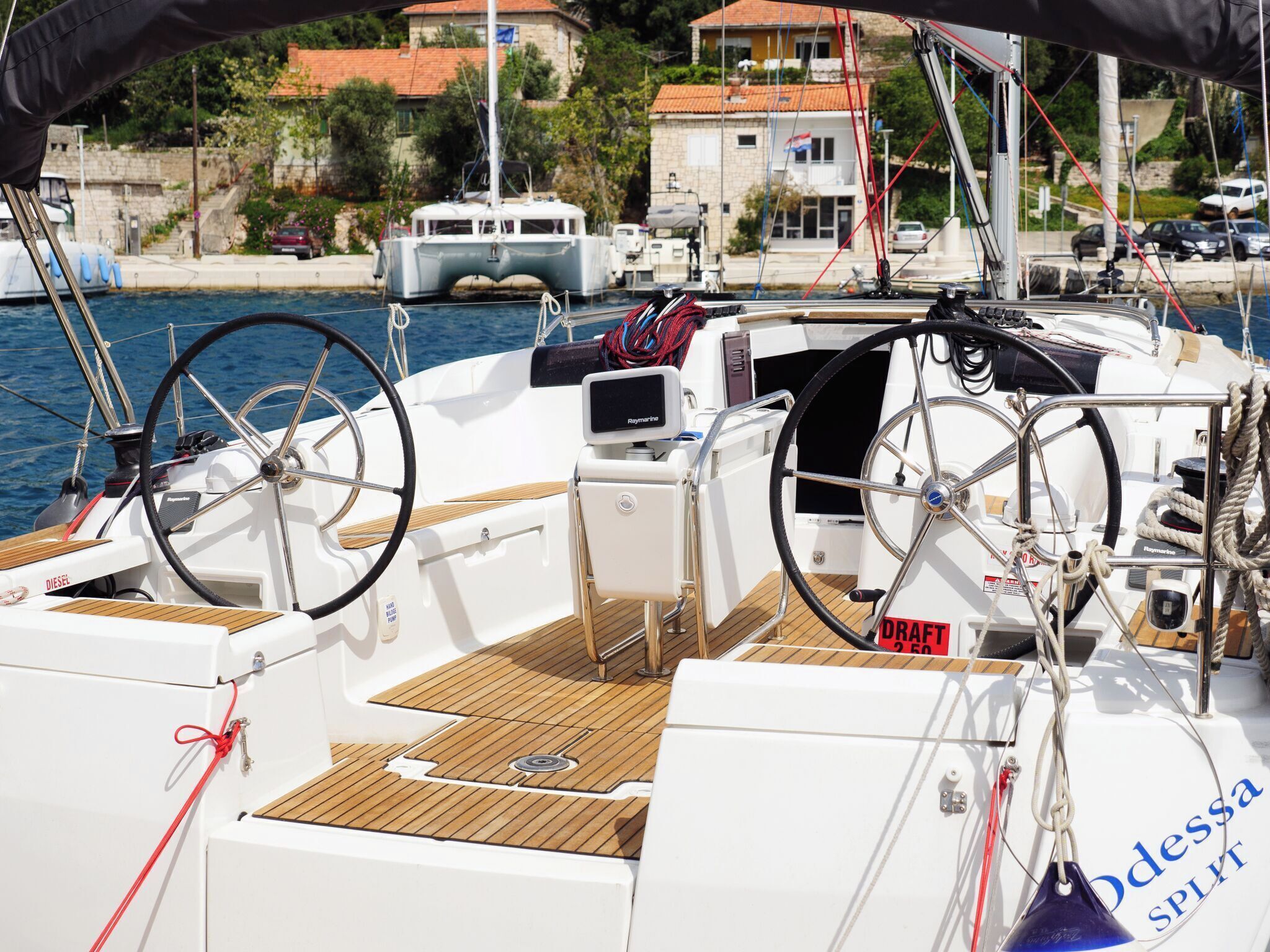 Cubierta de barco con timón, panel de control y el nombre 'Odessa SPLIT' en el costado.