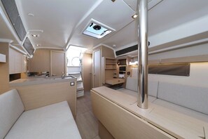 A compact, well-lit interior with a kitchenette, seating area, and a skylight. - Sibenik Sun-soaked Sailing: A Luxurious Croatian Voyage (Pirovac)