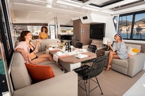 A modern interior with a dining area, sofas, and a view of the sea. - Sun-kissed Sailing Adventure in Split-Dalmatia, Croatia (Seget Donji)
