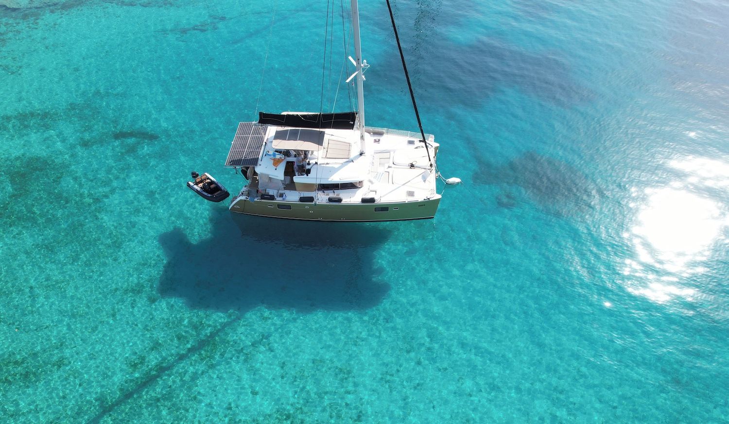 A boat on clear turquoise water with a cabin and deck area.