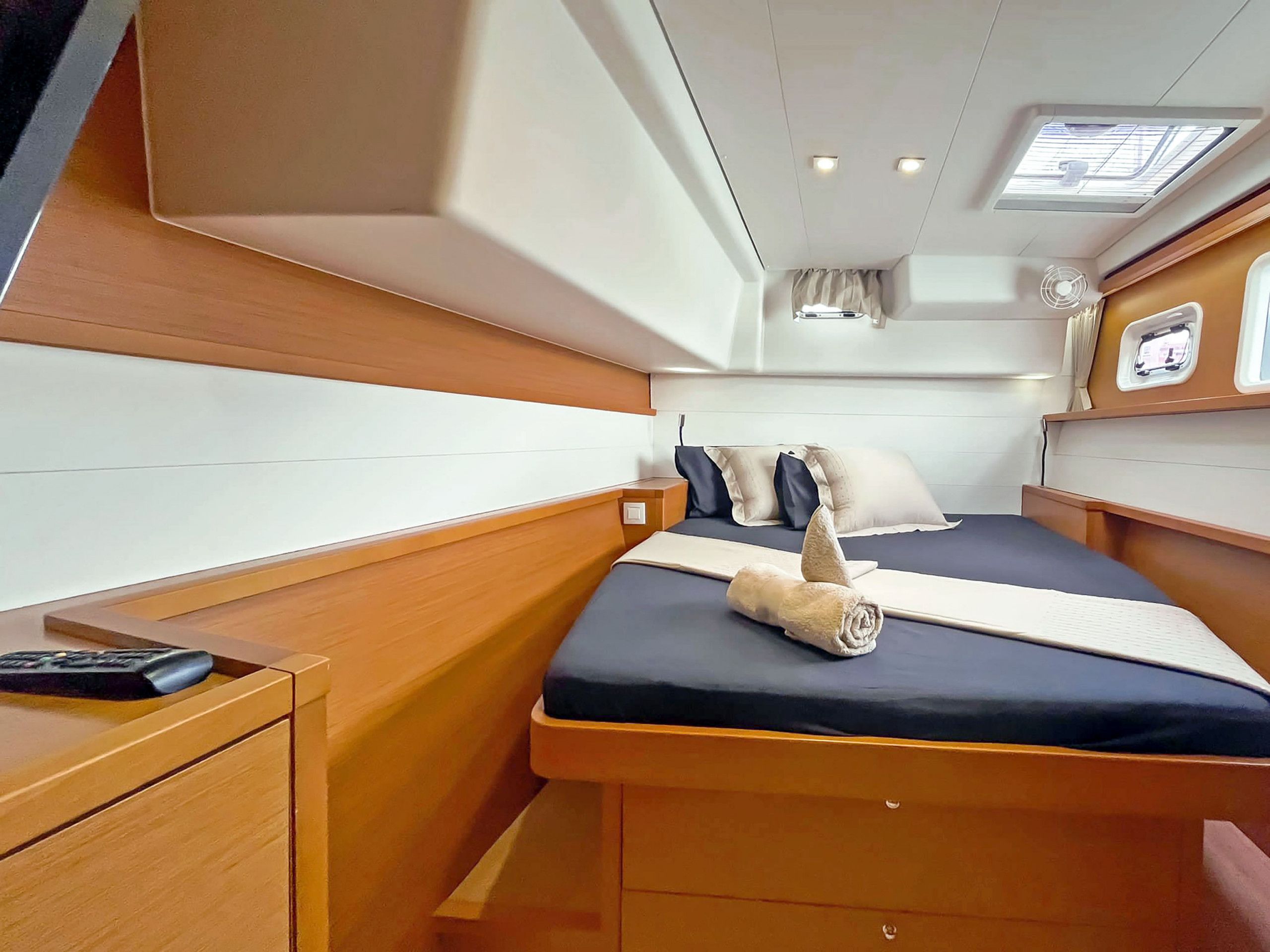 A compact cabin with a bed, bedside table, and a small window.