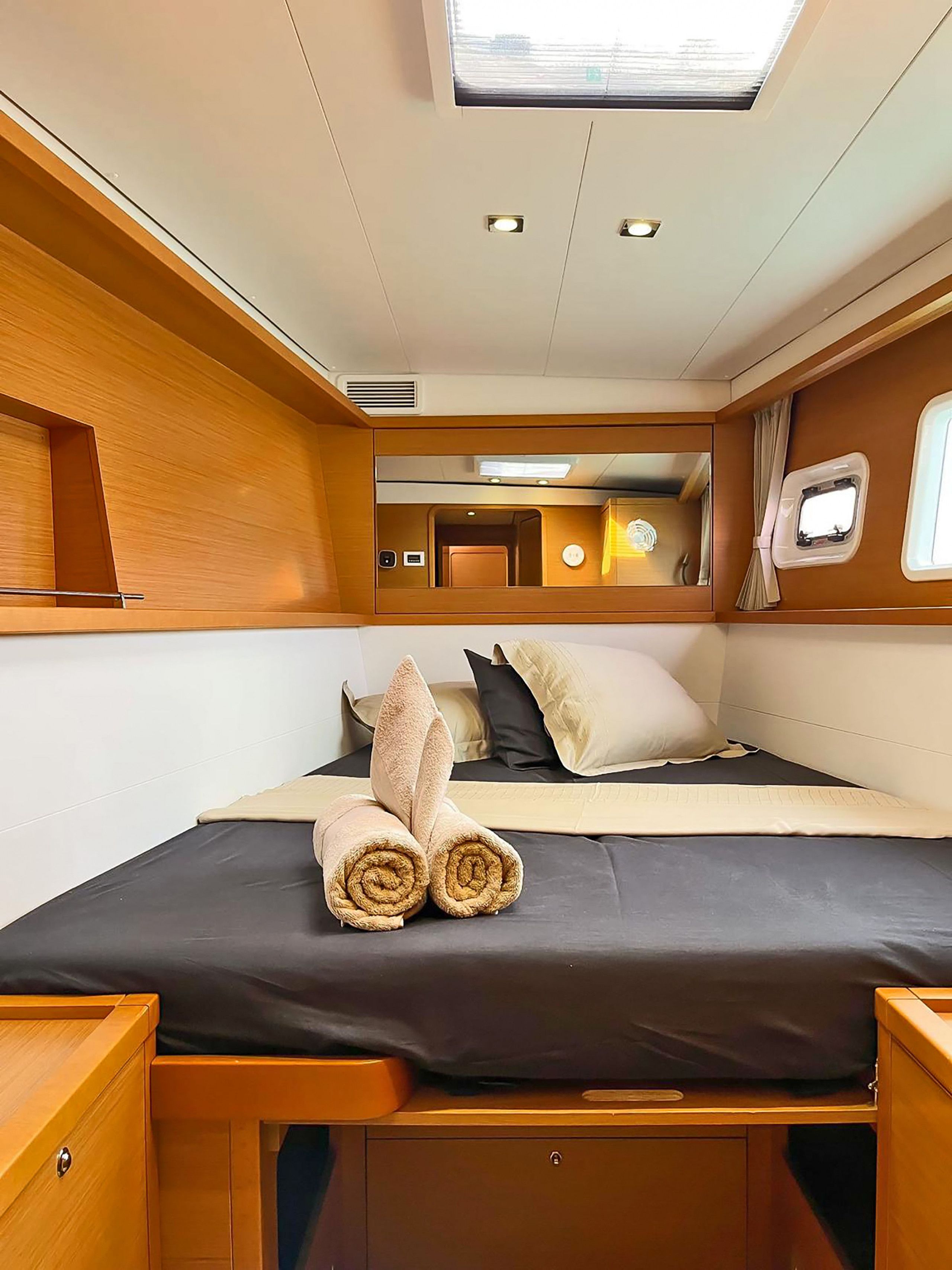 A compact, well-lit cabin with a bed, a small window, and a skylight.