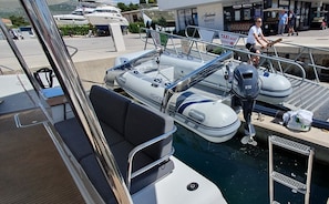A boat docked at a marina with a seating area, a motor, and a 'TAXI BOAT' sign. - Sun-kissed Sailing Adventure in Split-Dalmatia, Croatia (Seget Donji)