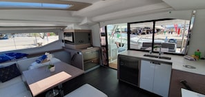 A compact galley with a sink, stove, and seating area. - Sun-kissed Sailing Adventure in Split-Dalmatia, Croatia (Seget Donji)