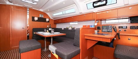 A compact, well-lit interior with a dining area, seating, and a control panel.