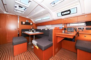 A compact, well-lit interior with a dining area, seating, and a control panel. - Sibenik Sun-Kissed Sailing: A Luxurious Beach Experience in Croatia (Murter)