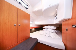 A compact cabin with a bunk bed, a small seating area, and a kitchenette. - Sibenik Sun-Kissed Sailing: A Luxurious Beach Experience in Croatia (Murter)