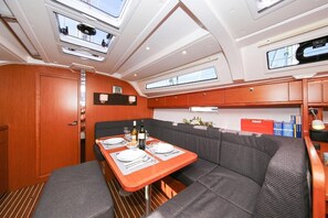 Una cocina pequeña y funcional con una mesa de comedor para dos personas, un lavamanos y espacio de almacenamiento superior.