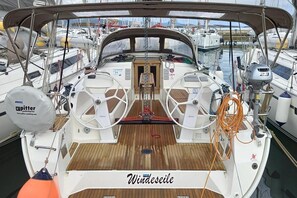 A boat deck with a steering wheel, a winch, and a covered area. - Sibenik Sun-Kissed Sailing: A Luxurious Beach Experience in Croatia (Murter)