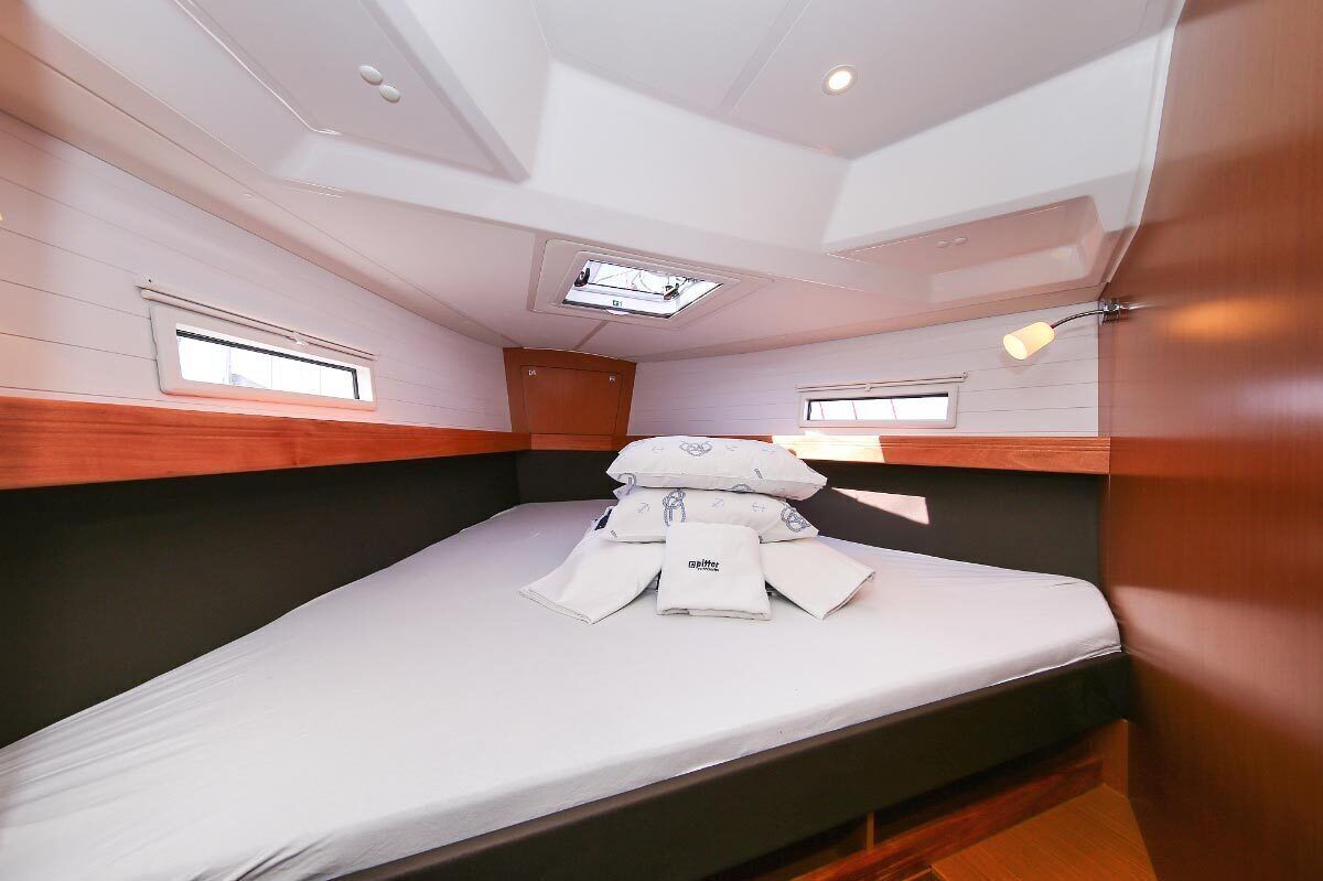 Une petite cabine comprenant un lit simple, un puits de lumière et deux petites fenêtres.