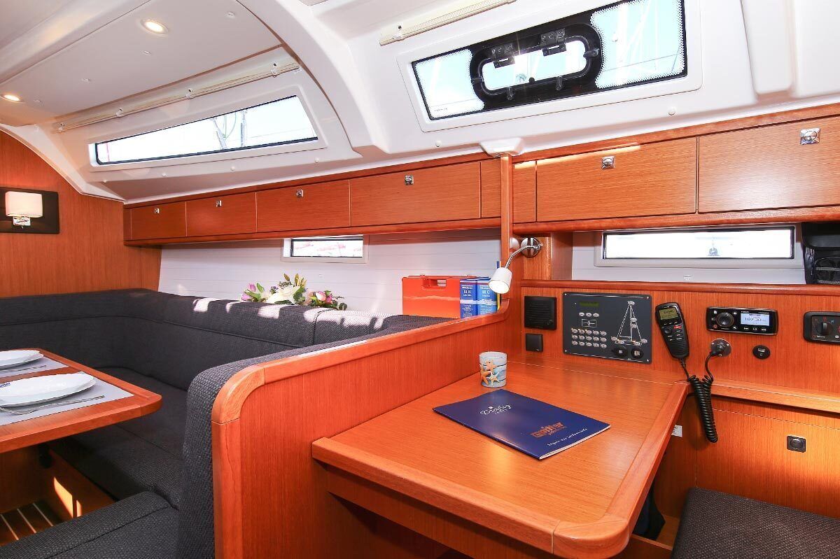 A cabin with a dining area, control panels, and a window.