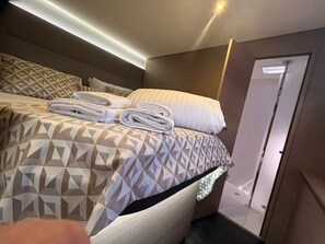 A hotel room with a bed, pillows, and a door. - Sun-kissed Sailing Adventure in Split-Dalmatia, Croatia (Seget Donji)