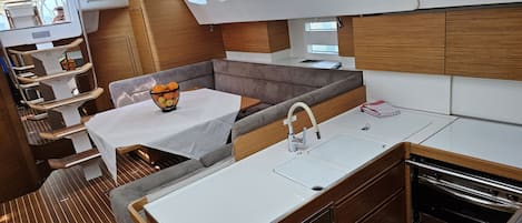 Una cocina pequeña con una mesa de comedor, un lavamanos y un horno compacto.