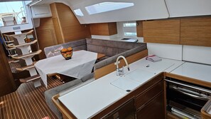 A compact galley with a dining table, a sink, and a compact oven.
