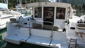 A white boat docked at a marina with a cabin, a small deck area, and a ladder. - Dubrovnik Delight: A Sun-Kissed Sailing Experience (Komolac)