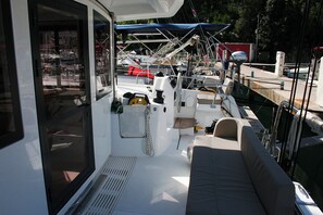 A boat deck with a cushioned seating area, a steering wheel, and various navigational equipment. - Dubrovnik Delight: A Sun-Kissed Sailing Experience (Komolac)