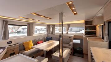 Een modern interieur van een camper met een eethoek, zitplaatsen en een keuken.