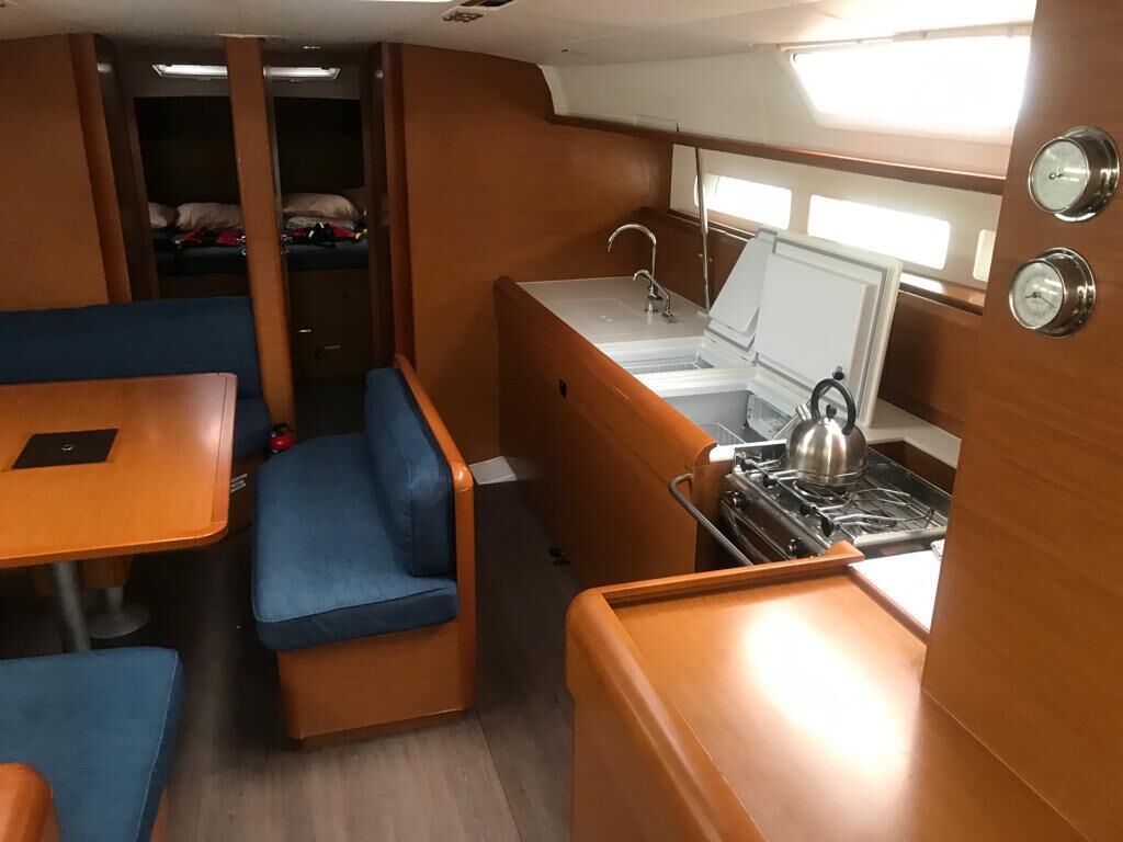 Une petite cuisine équipée d’une cuisinière, d’un évier et d’un coin repas.