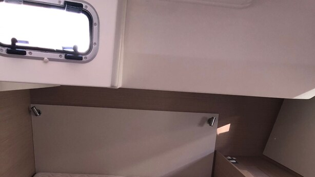 Cama compacta com cabeceira e janela acima.