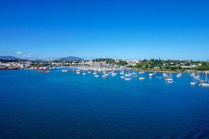 A coastal town with a marina filled with boats, a clear blue sky, and a hilly landscape in the background. - Sun-Kissed Sailing Adventure in Gran Laguna from Nueva Caledonia (Nouméa)