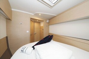 A hotel room with a bed, a door, and a ceiling light fixture. - Sun-kissed Sailing Adventure in Split-Dalmatia, Croatia (Seget Donji)