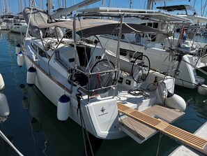 A marina with multiple sailboats docked, featuring a wooden deck, a steering wheel, and a winch. - Sun-Kissed Sailing Adventure in Zadar, Croatia (Bibinje)