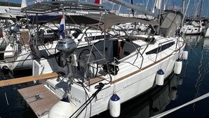 Un port de plaisance où sont amarrés de nombreux voiliers, dont un yacht blanc nommé « Lydia », dont on peut voir le moteur et qui arbore un pavillon néerlandais.