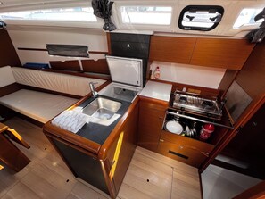 A compact galley with a sink, stove, and storage cabinets. - Sun-Kissed Sailing Adventure in Zadar, Croatia (Bibinje)