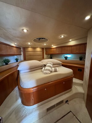 A compact, well-lit cabin with a bed, wooden cabinets, and a small potted plant. - Sun-Kissed Sailing Adventure in Sibenik, Croatia (Rogoznica)