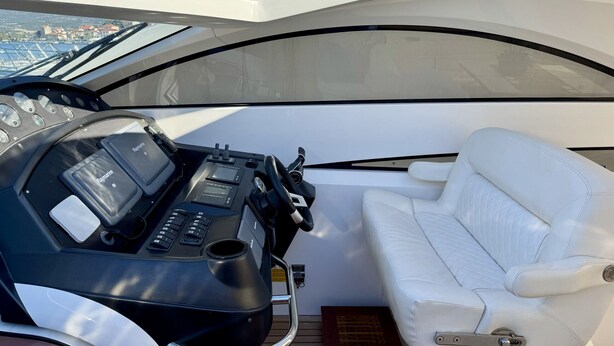 A boat's cockpit with a steering wheel, control panel, and a white cushioned seat. - Sun-Kissed Sailing Adventure in Sibenik, Croatia (Rogoznica)