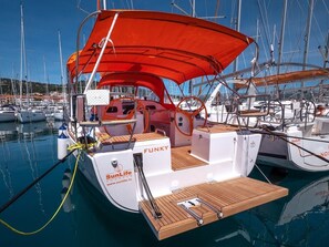 A sailboat docked at a marina with a red canopy, wooden deck, and the name 'SunLife Charter' visible. - Sun-Kissed Sailing Adventure in Split, Croatia (Split)