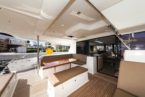 A yacht's deck with seating, a table, and a view of the marina. - Sun-kissed Sailing Adventure in Split-Dalmatia, Croatia (Trogir)