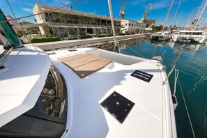 A marina with boats docked, a building with a restaurant, and a clear sky. - Sun-kissed Sailing Adventure in Split-Dalmatia, Croatia (Trogir)