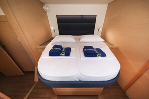 A double bed with white bedding and two towels with a logo. - Sun-kissed Sailing Adventure in Split-Dalmatia, Croatia (Trogir)