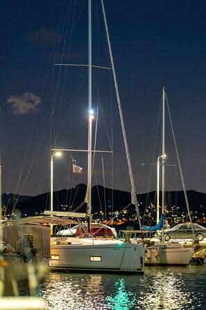 A marina with boats docked, a clear sky, and distant mountains. - Sun-Kissed Sailing Adventure in the Saronic Islands (Nea Peramos)