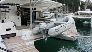 Uno yacht ormeggiato in marina, con un'area ponte coperta, posti a sedere e motore visibile.