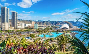 A cityscape with modern buildings, a large pool area, and a distinctive white dome structure.
