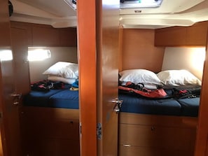 A compact cabin with two beds, each with pillows and blankets, and a small table.