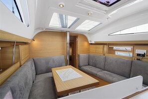 A modern interior with a wooden table, two grey sofas, and skylights.