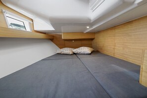 A compact room with a bunk bed, a skylight, and wooden paneling.