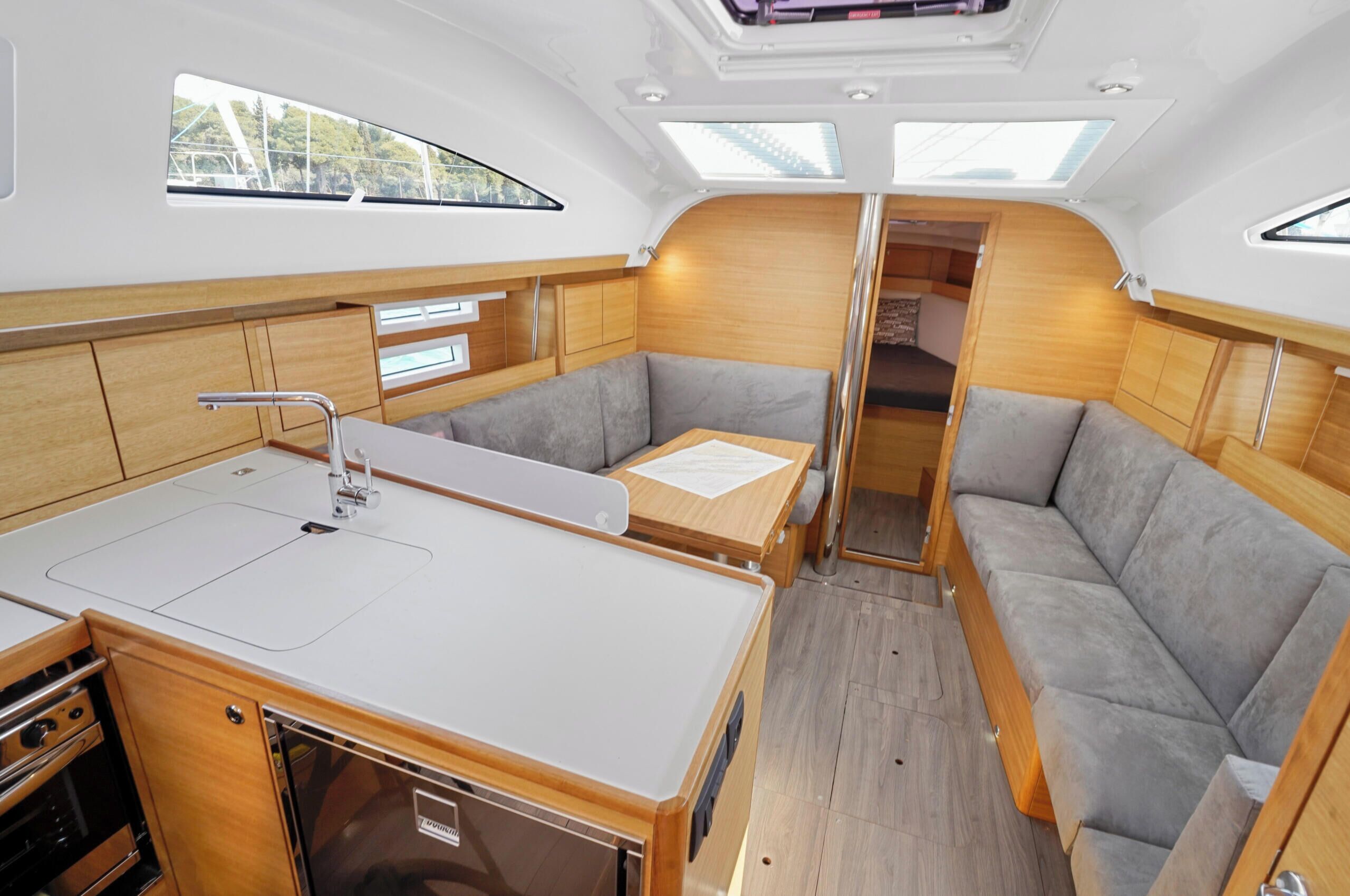 A compact boat interior with a kitchenette, seating area, and a small dining table.