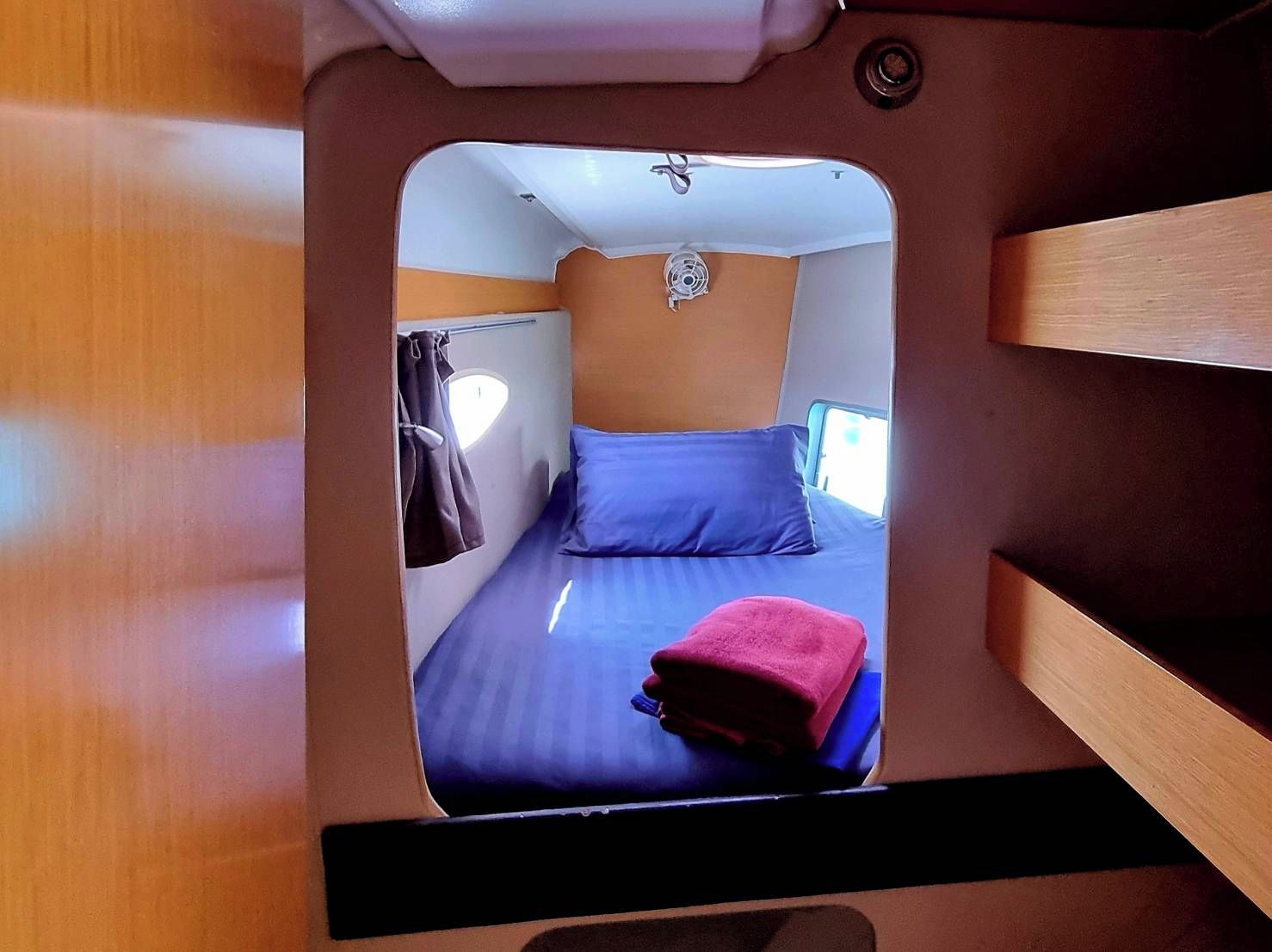 Un intérieur compact avec un lit superposé, une petite fenêtre et un ventilateur.