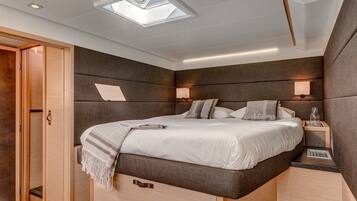 Une chambre à coucher moderne avec un puits de lumière, un lit avec une tête de lit, des tables de chevet et une armoire.