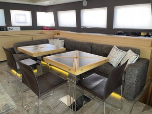 A modern kitchen with a built-in seating area, a dining table, and a microwave.