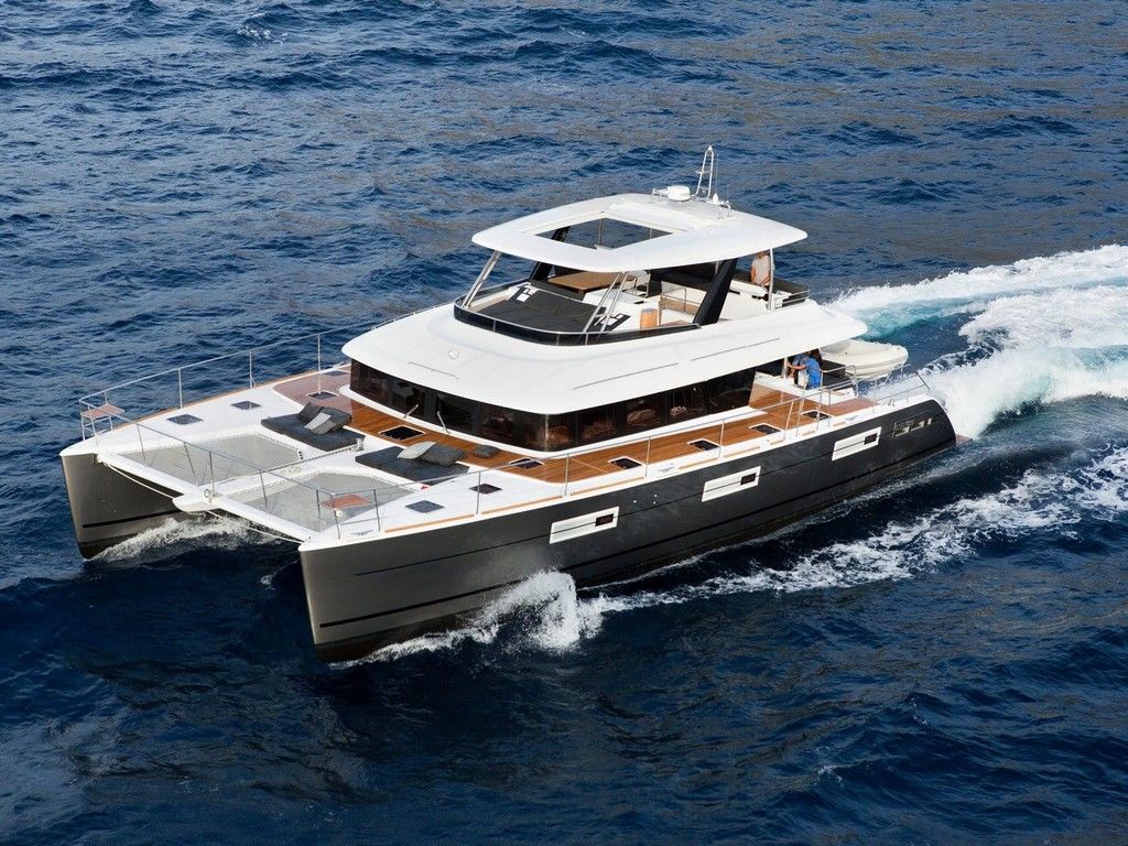 Un grand yacht doté d’un pont supérieur couvert, de plusieurs espaces salon et laissant une belle vague dans son sillage.