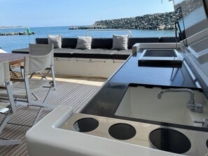 Un pont de bateau comprenant un espace salon, une table et un évier.